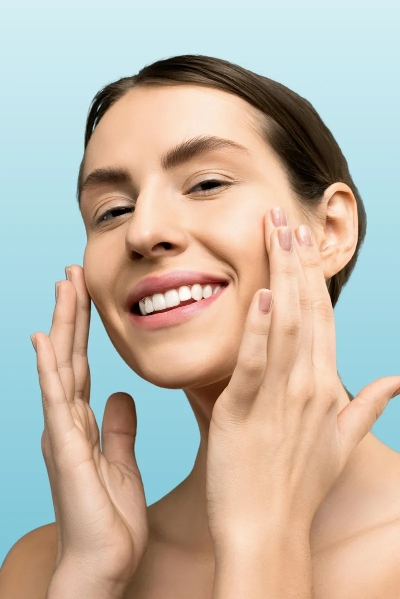 Smiling woman touching her face